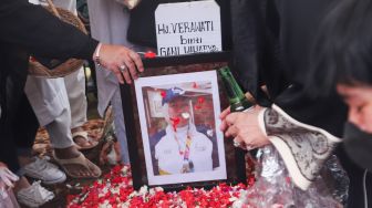 Keluarga menabur bunga diatas pusara mantan Atlet Bulutangkis Hj. Verawaty Fajrin usai dimakamkan di TPU Tanah Kusir, Jakarta Selatan, Minggu (21/11/2021). [Suara.com/Alfian Winanto]