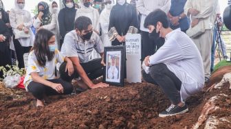 Keluarga berdoa diatas pusara mantan Atlet Bulutangkis Hj. Verawaty Fajrin usai dimakamkan di TPU Tanah Kusir, Jakarta Selatan, Minggu (21/11/2021). [Suara.com/Alfian Winanto]