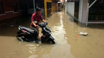 Warga menyelamatkan sepeda motornya yang terendam banjir di Kelurahan Pesurungan, Tegal, Jawa Tengah, Selasa (23/11/2021). ANTARA FOTO/Oky Lukmansya