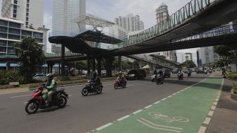 Sejumlah kendaraan melintas di bawah  proyek revitalisasi Jembatan Penyeberangan Orang (JPO) Sudirman di Jakarta, Selasa (23/11/2021). [Suara.com/Angga Budhiyanto]