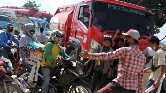 Warga menghalau sejumlah kendaraan untuk tidak melintasi jalan yang diblokir di Kecamatan Kasilampe, Kendari, Sulawesi Tenggara, Selasa (23/11/2021).  ANTARA FOTO/Jojon