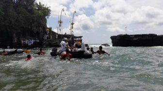 Umat Bisa Menyebrang ke Pura Luhur Tanah Lot Dengan Perahu Karet Saat Ombak Pasang