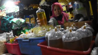 Pedagang menata minyak goreng curah di Pasar Inpres Pasar Minggu, Jakarta, Jumat (26/11/2021). ANTARA FOTO/Indrianto Eko Suwarso