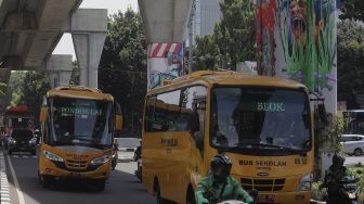 Sejumlah kendaraan melintas di dekat mural bertema COVID-19 di Jakarta, Jumat (26/11/2021). [Suara.com/Angga Budhiyanto]