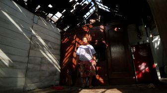 Pateni (61) berada di dalam rumahnya yang mengalami kerusakan pada bagian atap setelah cbeliung di Dusun Puri, Desa Puri Semanding, Kecamatan Plandaan, Kabupaten Jombang, Jawa Timur, Jumat (26/11/2021). ANTARA FOTO/Syaiful Arif