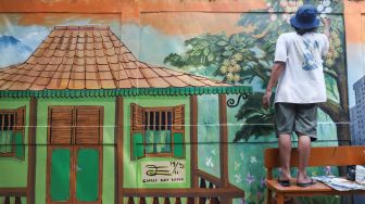 Warga menyelesaikan pembuatan mural dengan tema Jakarta di Kebayoran Lama, Jakarta Selatan, Jumat (26/11/2021). [Suara.com/Alfian Winanto]