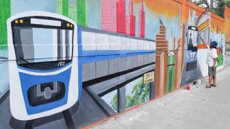 Warga menyelesaikan pembuatan mural dengan tema Jakarta di Kebayoran Lama, Jakarta Selatan, Jumat (26/11/2021). [Suara.com/Alfian Winanto]