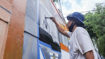 Warga menyelesaikan pembuatan mural dengan tema Jakarta di Kebayoran Lama, Jakarta Selatan, Jumat (26/11/2021). [Suara.com/Alfian Winanto]