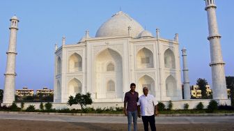 Pengusaha India Anand Prakash Chouksey (kanan) dan putranya Kabir berpose di depan replika Taj Mahal, Burhanpur, negara bagian Madhya Pradesh, India, pada (25/11/2021). [UMA SHANKAR MISHRA / AFP]