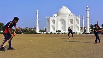 Anak-anak bermain kriket di depan replika Taj Mahal, Burhanpur, negara bagian Madhya Pradesh, India, pada (25/11/2021). [UMA SHANKAR MISHRA / AFP]