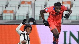 Gelandang Juventus Juan Cuadrado (kiri) berebut bola dengan penyerang Atalanta Duvan Zapata selama pertandingan sepak bola Serie A Italia Juventus melawan Atalanta di Stadion Allianz, Turin, Sabtu (27/11/2021). Isabella BONOTTO / AFP