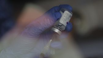 Vaksinator mempersiapkan vaksin COVID-19 sebelum disuntikkan kepada warga di RPTRA Taman Mandala, Tebet, Jakarta, Senin (29/11/2021). [Suara.com/Angga Budhiyanto]