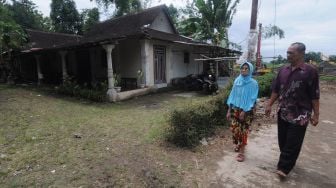 Seorang ibu yang menjadi tergugat dalam kasus sengketa warisan, Sri Surantini (kiri) didampingi anak pertamanya Gunawan Joko (kanan) saat melihat kondisi pekarangan rumahnya di Guwokajen, Sawit, Boyolali, Jawa Tengah, Minggu (28/11/2021). ANTARA FOTO/Aloysius Jarot Nugroho
