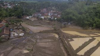 Foto udara lahan pertanian yang diterjang banjir bandang di Kampung Cilowa, Kecamatan Sukawening, Kabupaten Garut, Jawa Barat, Minggu (28/11/2021).  ANTARA FOTO/Adeng Bustomi