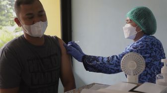 Vaksinator menyuntikkan vaksin COVID-19 kepada warga di RPTRA Taman Mandala, Tebet, Jakarta, Senin (29/11/2021). [Suara.com/Angga Budhiyanto]