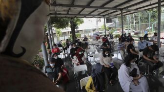 Sejumlah warga mengantre untuk mendapatkan vaksin COVID-19 di RPTRA Taman Mandala, Tebet, Jakarta, Senin (29/11/2021). [Suara.com/Angga Budhiyanto]