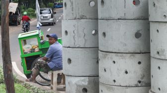 Warga beraktivitas di dekat buis beton drainase vertikal di kawasan Manggarai, Jakarta Selatan, Selasa (30/11/2021). [Suara.com/Alfian Winanto] 