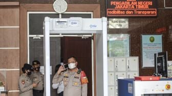 Sejumlah polisi berjaga di depan ruangan saat berjalannya sidang perdana kasus dugaan terorisme dengan terdakwa Munarman yang berjalan secara daring di Pengadilan Negeri Jakarta Timur, Rabu (1/12/2021).  ANTARA FOTO/M Risyal Hidayat