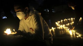 Relawan menyalakan lampu dalam malam renungan Hari AIDS Sedunia di Tanah Abang, Jakarta, Rabu (1/12/2021). [Suara.com/Angga Budhiyanto]