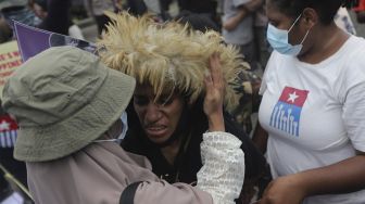 Massa aksi berpelukan saat memperingati 60 tahun deklarasi kemerdekaan Papua Barat di kawasan Patung Kuda Arjuna Wiwaha, Jakarta, Rabu (1/12/2021). [Suara.com/Angga Budhiyanto]