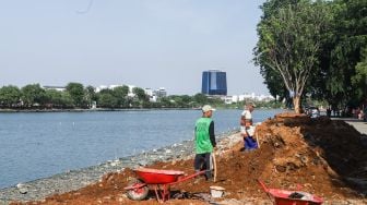 Pekerja menyelesaikan proyek revitalisasi Danau Sunter di Sunter, Jakarta Utara, Kamis (2/12/2021). [Suara.com/Alfian Winanto]