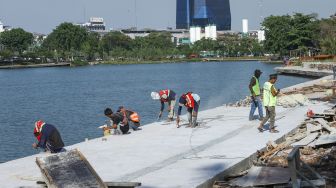 Pekerja menyelesaikan proyek revitalisasi Danau Sunter di Sunter, Jakarta Utara, Kamis (2/12/2021). [Suara.com/Alfian Winanto]