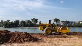 Pekerja mengoperasikan alat berat untuk menyelesaikan proyek revitalisasi Danau Sunter di Sunter, Jakarta Utara, Kamis (2/12/2021). [Suara.com/Alfian Winanto]