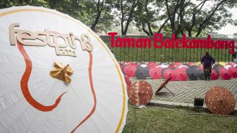 Pengunjung melihat-lihat payung yang dipamerkan pada Festival Payung 2021 di Taman Balekambang, Solo, Jawa Tengah, Jumat (3/12/2021). [ANTARA FOTO/Mohammad Ayudha]