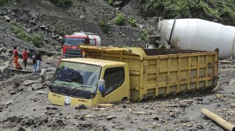 Warga menyaksikan truk yang terjebak lahar hujan di aliran sungai Senowo kawasan lereng Gunung Merapi Dusun Trono, Krinjing, Dukun, Magelang, Jateng, Kamis (2/12/2021). [ANTARA FOTO/Anis Efizudin]