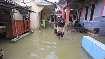 Warga melintasi banjir rob yang melanda desa Eretan Wetan, Kandanghaur, Indramayu, Jawa Barat, Sabtu (4/12/2021).  ANTARA FOTO/Dedhez Anggara