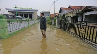 Warga melintasi banjir rob yang melanda desa Eretan Wetan, Kandanghaur, Indramayu, Jawa Barat, Sabtu (4/12/2021).  ANTARA FOTO/Dedhez Anggara