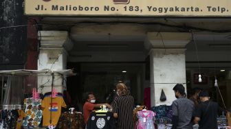 Pedagang Kaki Lima (PKL) melayani pembeli di kawasan Malioboro, Yogyakarta, Minggu (5/12/2021). [ANTARA FOTO/Andreas Fitri Atmoko]