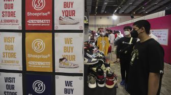 Pengunjung mengamati produk yang ditawarkan pada acara Urban Sneaker Society 2021 di Jakarta Convention Center, Senayan, Jakarta, Minggu (5/12/2021). [Suara.com/Angga Budhiyanto]