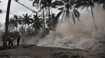 Relawan mengamati kepulan asap yang berasal dari material guguran awan panas Gunung Semeru di Desa Sumber Wuluh, Lumajang, Jawa Timur, Minggu (5/12/2021). [ANTARA FOTO/Zabur Karuru]
