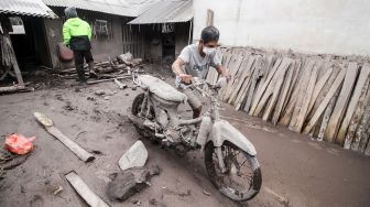 Warga mengevakuasi kendaraannya yang tertimbun material guguran awan panas Gunung Semeru di Desa Sumber Wuluh, Lumajang, Jawa Timur, Senin (6/12/2021).  ANTARA FOTO/Umarul Faruq
