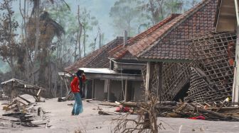 Seorang warga mengumpulkan barang yang tersisa dari rumahnya yang hancur di desa Supiturang, Lumajang, Jawa Timur, Selasa (7/12/2021). ANTARA FOTO/Ari Bowo Sucipto