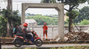 Kendaraan melintas di depan box culvert pembangunan saluran air di Jalan I Gusti Ngurah Rai, Duren Sawit, Jakarta Timur, Selasa (7/12/2021). [Suara.com/Alfian Winanto]