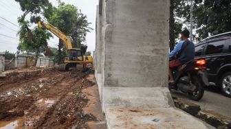 Suasana pembangunan saluran air di Jalan I Gusti Ngurah Rai, Duren Sawit, Jakarta Timur, Selasa (7/12/2021). [Suara.com/Alfian Winanto]