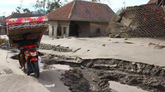 Seorang warga mengumpulkan barang yang tersisa dari rumahnya yang hancur di desa Supiturang, Lumajang, Jawa Timur, Selasa (7/12/2021).  ANTARA FOTO/Ari Bowo Sucipto