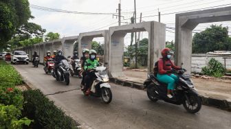 Kendaraan melintas di jalur pembangunan saluran air di Jalan I Gusti Ngurah Rai, Duren Sawit, Jakarta Timur, Selasa (7/12/2021). [Suara.com/Alfian Winanto]