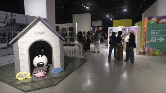 Sejumlah pengunjung mengamati instalasi seni dalam pameran Popart Jakarta di Space8 Astha, Kawasan Niaga Terpadu Sudirman, Kebayoran Baru, Jakarta, Selasa (7/12/2021). [Suara.com/Angga Budhiyanto]