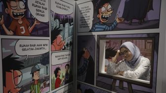 Pengunjung berfoto di instalasi seni dalam pameran Popart Jakarta di Space8 Astha, Kawasan Niaga Terpadu Sudirman, Kebayoran Baru, Jakarta, Selasa (7/12/2021). [Suara.com/Angga Budhiyanto]