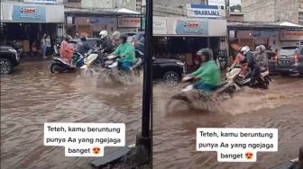 Pasangan Naik Motor di Tengah Banjir Curi Perhatian, Warganet: Iri Meronta