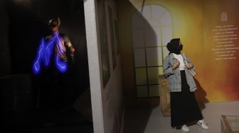 Pengunjung berfoto di dekat instalasi seni dalam pameran Popart Jakarta di Space8 Astha, Kawasan Niaga Terpadu Sudirman, Kebayoran Baru, Jakarta, Selasa (7/12/2021). [Suara.com/Angga Budhiyanto]