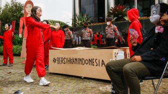 Sejumlah aktivis dari Indonesia Corruption Watch (ICW) dan Gerakan #BersihkanIndonesia mengenakan kostum dari film Money Heist saat melakukan aksi unjuk rasa di Gedung KPK, Jakarta Selatan, Rabu (8/12/2021). [Suara.com/Alfian Winanto]