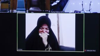 Artis Cynthiara Alona menangis ketika mendengar putusan majelis hakim saat menjalani sidang kasus prostitusi anak yang digelar secara virtual di Pengadilan Negeri Tangerang, Banten, Rabu (8/12/2021). [Suara.com/Alfian Winanto]