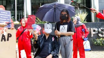 Sejumlah aktivis dari Indonesia Corruption Watch (ICW) dan Gerakan #BersihkanIndonesia mengenakan kostum dari film Money Heist saat melakukan aksi unjuk rasa di Gedung KPK, Jakarta Selatan, Rabu (8/12/2021). [Suara.com/Alfian Winanto]