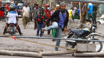 Wisatawan menerobos penghalang jalan untuk melihat dari dekat lokasi bencana letusan gunung Semeru di dusun Sumbersari, Pronojiwo, Lumajang, Jawa Timur, Kamis (9/12/2021). ANTARA FOTO/Ari Bowo Sucipto