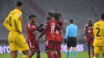 Gelandang Bayern Munich Jerman Leroy Sane (kedua dari kanan) merayakan skor 2-0 dengan rekan satu timnya pemain depan Bayern Munich dari Prancis Kingsley Coman (kiri) dan gelandang Bayern Munich dari Kanada Alphonso Davies (kedua dari kiri) selama pertandingan sepak bola grup E Liga Champions UEFA FC Bayern Munich melawan Barcelona di  di Allianz Arena, Kamis (9/12/2021) dini hari WIB. Christof STACHE / AFP
