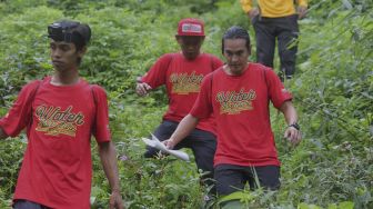 Tim dari Rikas Harsa berjalan menuruni bukit saat mengikuti kompetisi Water Adventure Jelajah Air Nusantara di Desa Ciasihan, Kecamatan Pamijahan, Kabupaten Bogor, Jawa Barat, Kamis (9/12/2021). [Suara.com/Angga Budhiyanto]